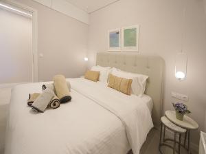 a white bedroom with a large white bed with pillows at Sam Casa Luxury Living in Kastoria