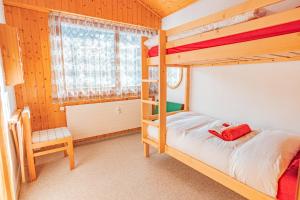 1 Schlafzimmer mit 2 Etagenbetten und einem Stuhl in der Unterkunft Muverans II F5 - 8 pers - duplex in Nendaz