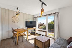 een woonkamer met een tafel en een televisie bij Balcon des Alpes 02 - 4 pers - au calme in Nendaz