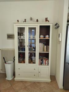 a white cabinet with glass doors in a kitchen at Camilla House in Varenna