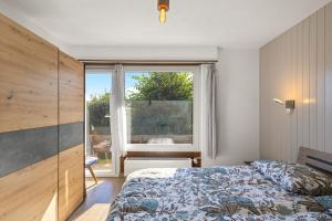 een slaapkamer met een bed en een groot raam bij Balcon des Alpes 02 - 4 pers - au calme in Nendaz