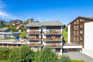 een appartementencomplex met balkons en een parkeerplaats bij Balcon des Alpes 02 - 4 pers - au calme in Nendaz