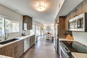a kitchen with wooden cabinets and a sink and a stove at Stunning Tempe Home with Pool - Near ASU Campus! in Tempe