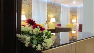 - un bouquet de fleurs rouges et blanches dans le hall dans l'établissement Solar Guesthouse Olival da Vinha, à Castelo de Paiva