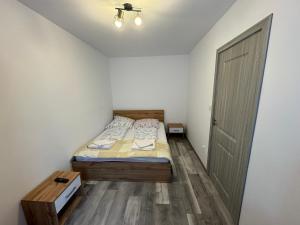 - une petite chambre avec un lit et une porte dans l'établissement Apartament Andreas, à Băile Herculane