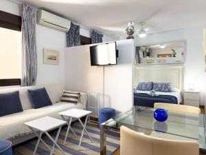 ein Wohnzimmer mit einer Couch und einem Tisch in der Unterkunft Estudio Playa Palo in Málaga + 21 Fotos