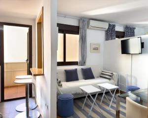 ein Wohnzimmer mit einer Couch und einem Tisch in der Unterkunft Estudio Playa Palo in Málaga