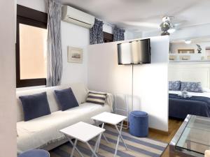 ein Wohnzimmer mit einer Couch und einem Bett in der Unterkunft Estudio Playa Palo in Málaga