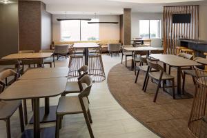 a dining room with tables and chairs and a tv at SpringHill Suites by Marriott Ardmore in Ardmore