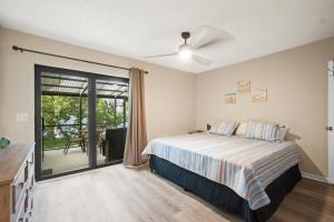Un dormitorio con una cama y una puerta corrediza de vidrio. en 2 Bed/2 Bath Beach Condo, en St. Augustine