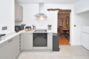 een witte keuken met een wastafel en een fornuis bij Chapel House, Where Comfort Meets Convenience - BOOK NOW! in Sandbach