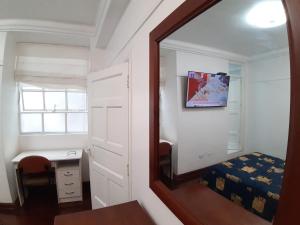 a mirror in a room with a bed and a desk at APARTAMENTO LINDO - A 2 Cuadras de la Plaza de Armas y del Palacio de Gobierno in Lima