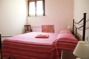 1 dormitorio con 1 cama con manta roja en Il Gelso di Francesco - N4, en Cecina
