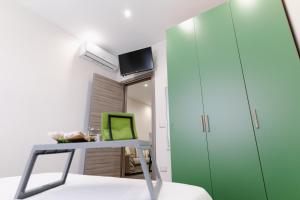 普利亞區格拉維納的住宿－Sotto Casa B&B，客房设有书桌和绿色橱柜。