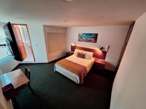 a hotel room with a bed and a television at Hotel Estación Sabana in Zipaquirá