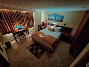 1 dormitorio con 1 cama y escritorio con ordenador portátil en Hotel Estación Sabana, en Zipaquirá
