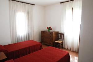 a bedroom with two beds and a dresser and windows at Il Gelso di Francesco - N5 in Cecina