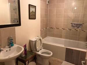 een badkamer met een toilet, een wastafel en een bad bij Jacks Court B4c in Stalybridge