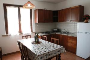 uma cozinha com uma mesa e um frigorífico branco em Il Gelso di Francesco - N5 em Cecina