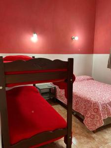 a bedroom with two bunk beds with red walls at Departamento 2 ambientes in Bella Vista