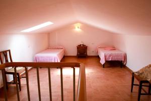 een zolderkamer met 2 bedden en een trap bij Il Gelso di Francesco - N5 in Cecina