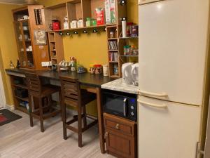 a kitchen with a table and a refrigerator at Jacks Court B4c in Stalybridge