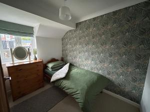 a small bedroom with a bed and a mirror at 2 Priests Mews in Swanage