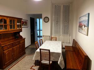 サヴォーナにあるCasa vacanza "Collodi"のダイニングルーム(テーブル、椅子、時計付)