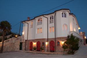 a large white building with red doors at night at Casa Oasa in Marezige