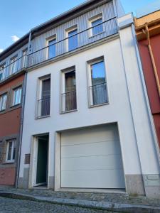 a white building with a two garage doors at Casa Augusta 4 in Braga