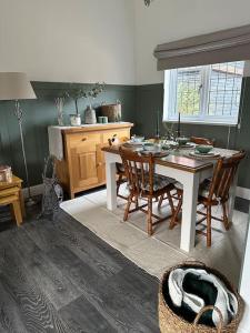a dining room with a table and chairs and a window at Barn with Hot Tub in Goffs Oak