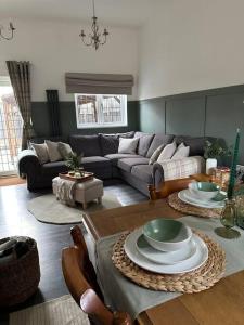 ein Wohnzimmer mit einem Sofa und einem Tisch in der Unterkunft Barn with Hot Tub in Goffs Oak