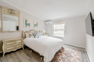 um quarto branco com uma cama e uma janela em Modern Cozy Waterfront Cottage with Fireplace em Livingston Manor