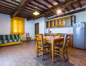 uma cozinha e sala de jantar com uma mesa e um frigorífico em Podere Simonetta - A8 em Cecina
