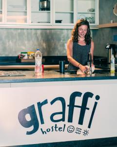 a woman standing at a counter in a kitchen at Graffi Beach House in Florianópolis