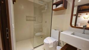 a bathroom with a shower and a toilet and a sink at Chalé Del Mar in Morro de São Paulo