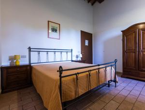 een slaapkamer met een bed en een houten dressoir bij Podere Simonetta - A11 in Cecina