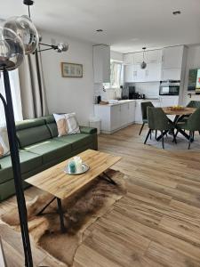 a living room with a green couch and a table at Vila Ivona in Divčibare