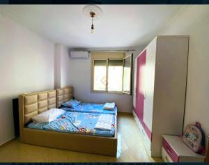 um pequeno quarto com uma cama e uma janela em Seaview em Vlorë