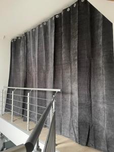 ein schwarzer Vorhang in einem Zimmer mit einer Treppe in der Unterkunft FREIGEIST ZeitRaum in Haßloch