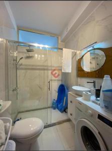 uma casa de banho com um chuveiro e uma máquina de lavar roupa em Seaview em Vlorë