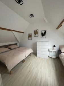 ein weißes Schlafzimmer mit 2 Betten und einer Kommode in der Unterkunft FREIGEIST ZeitRaum in Haßloch
