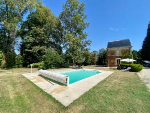 a swimming pool in a yard next to a house at Château de Belleaucourt 
