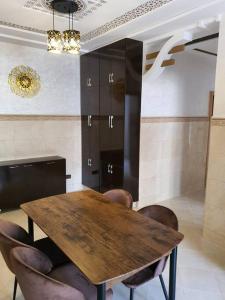a dining room with a wooden table and chairs at Mooi appartement, Route el Aounia Oujda in Oujda