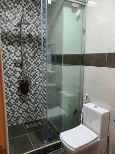a bathroom with a toilet and a glass shower at Mooi appartement, Route el Aounia Oujda in Oujda