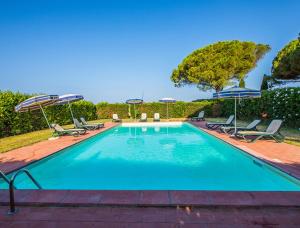 een zwembad met stoelen en parasols bij Podere La Pinetina - Ct1 in Cecina