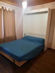 - une petite chambre avec un lit bleu dans l'établissement Casa Sustentable Mint Fields, à El Talar de Pacheco
