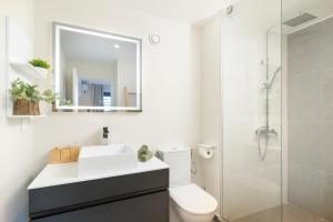a bathroom with a toilet and a sink and a shower at Tetavake Luxury Suite in Punaauia
