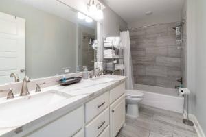 a bathroom with a sink and a toilet and a mirror at Bright Townhouse Downtown Lake Charles in Lake Charles