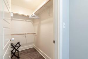 a walk in closet with white walls and wood floors at Bright Townhouse Downtown Lake Charles in Lake Charles +9 photos